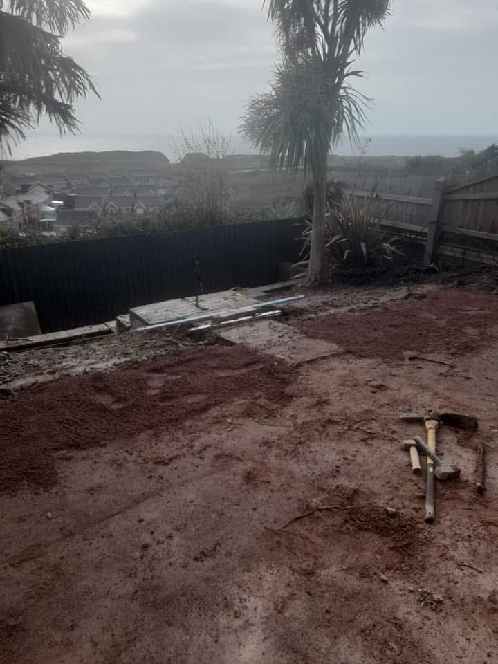 Bare red earth garden with sea view before patio installation