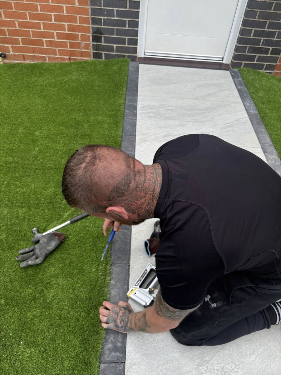 Scott trimming artificial grass precisely against a newly laid path